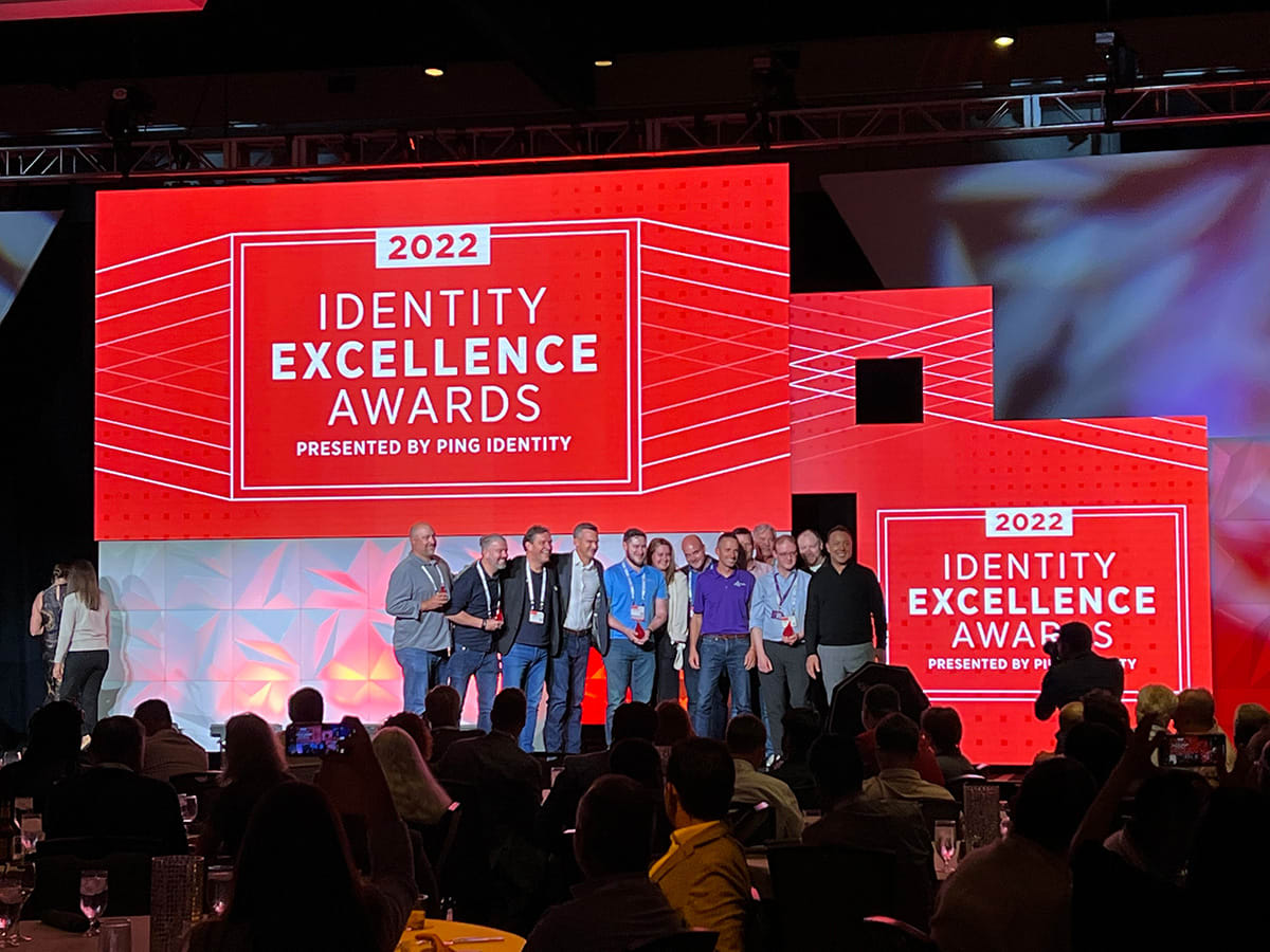 A photo of a group of customers who won Identity Excellence Awards smiling for a photo onstage with Ping Identity CEO, Andre Durand.