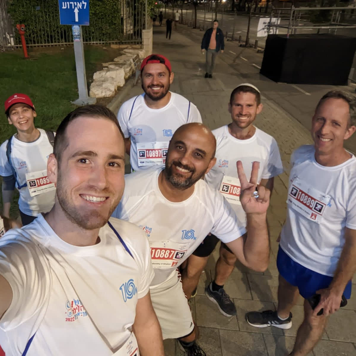 A photo of a group of Ping Identity employees posing outdoors after running in a fundraising 10K night run in Israel.
