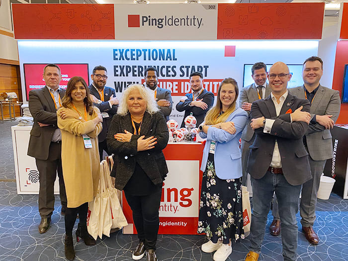 A photo of Ping employees posing with their arms crossed in a self embrace to symbolize Ping Identity's International Women's Day 2023 theme of #EmbraceEquity.