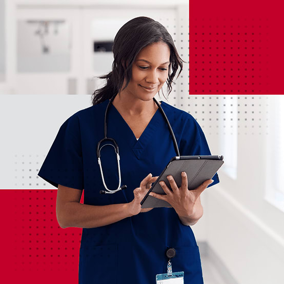 Female healthcare worker smiling while looking down at tablet