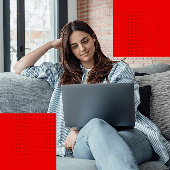 Woman sitting on couch looking at laptop