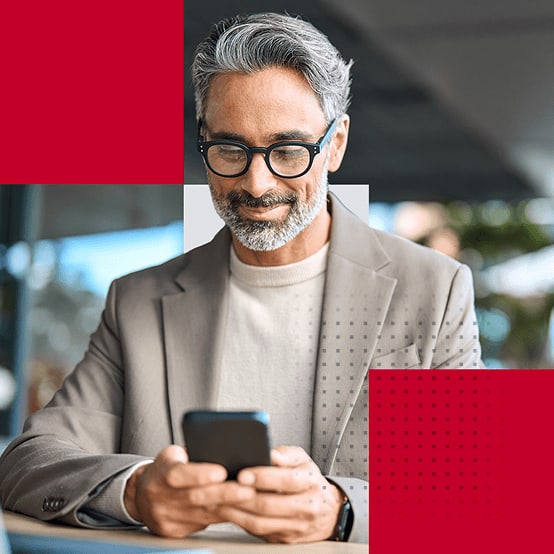 Business man smiling while looking down at his phone