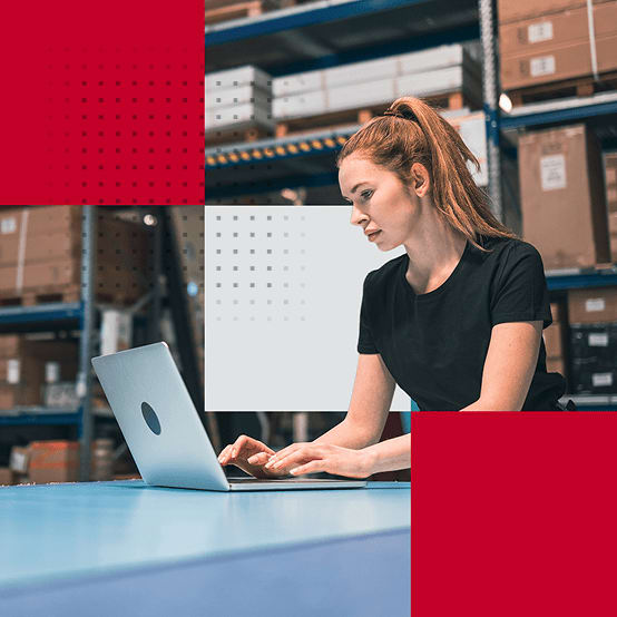 Woman in a warehouse working on a laptop
