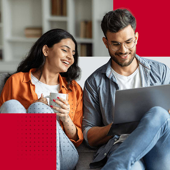 Man and woman smiling while looking at laptop