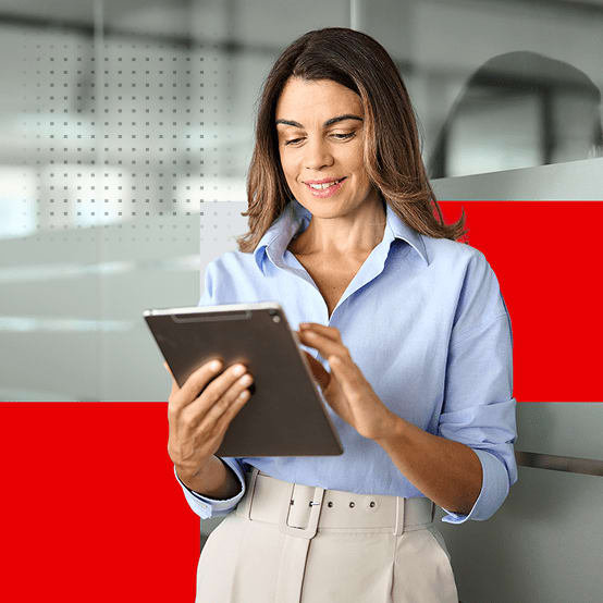 Woman at work smiling while working on tablet