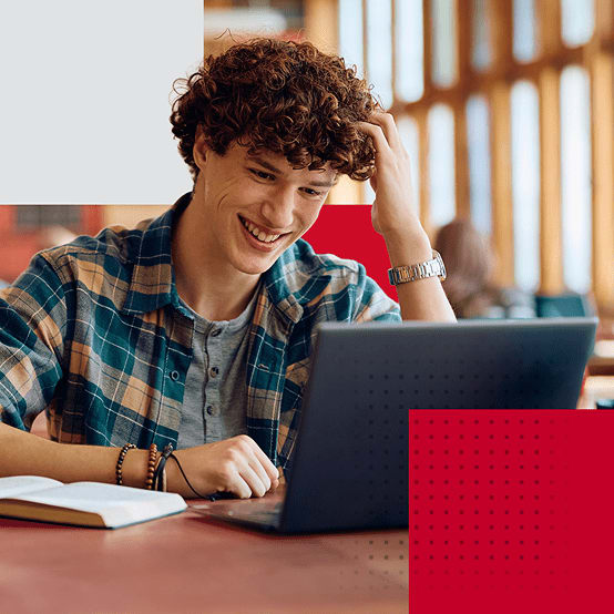 Young man smiling while looking at laptop