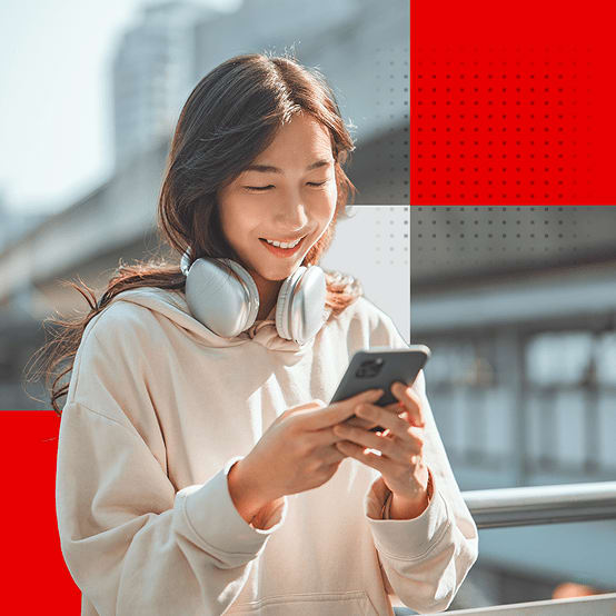 Women standing outside smiling while looking at phone
