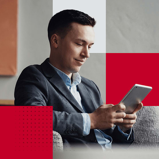 Man smiling while working on tablet