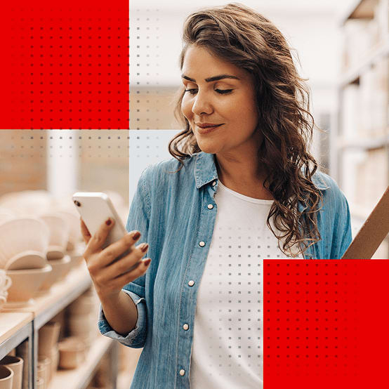 Woman holding a clipboard while looking at phone
