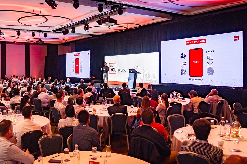 Speaker presenting at a tech conference to seated audience